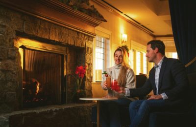 couple dining by fireplace in The Wharf