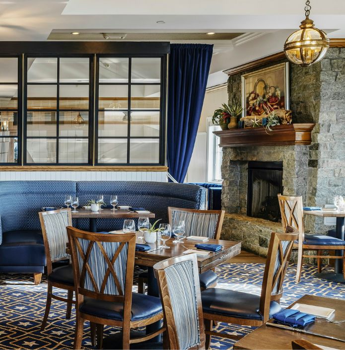 main dining room with tables, chairs, fireplace.